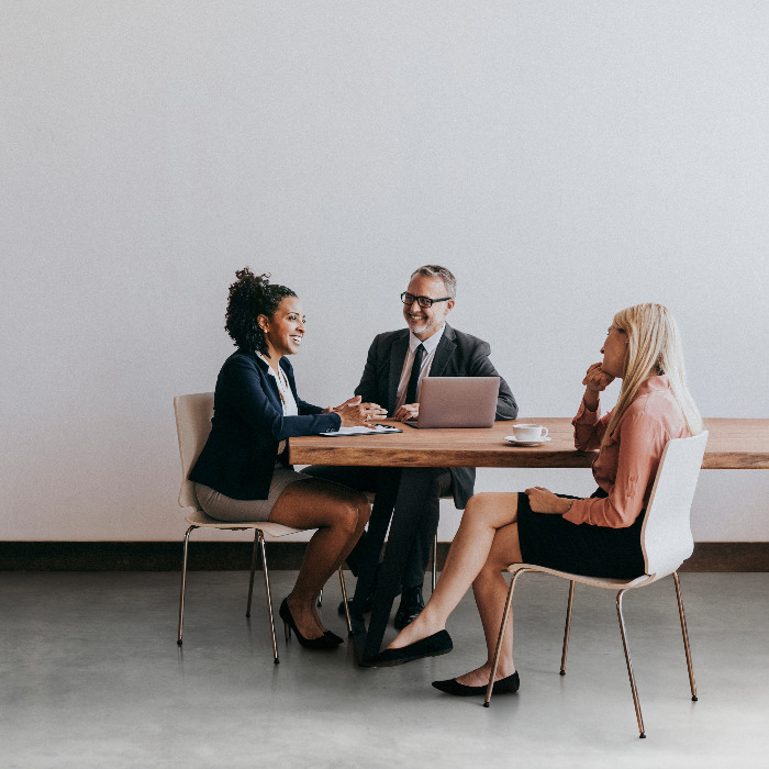 Three people at a table with a labtop