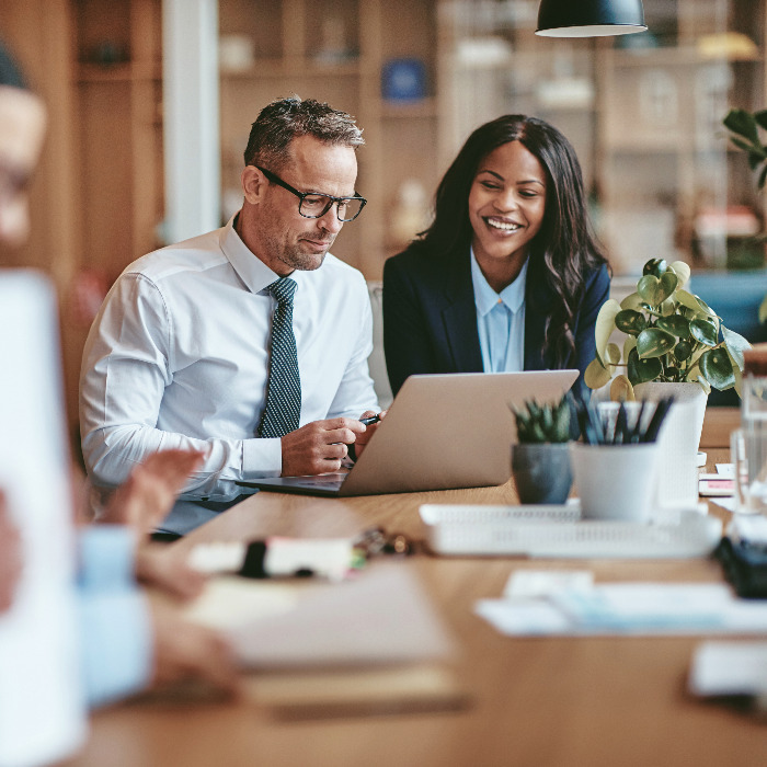 Man and woman in business clothes looking at a computer