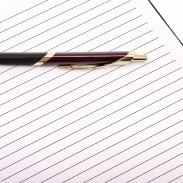 A pen laid on an open and blank notebook page