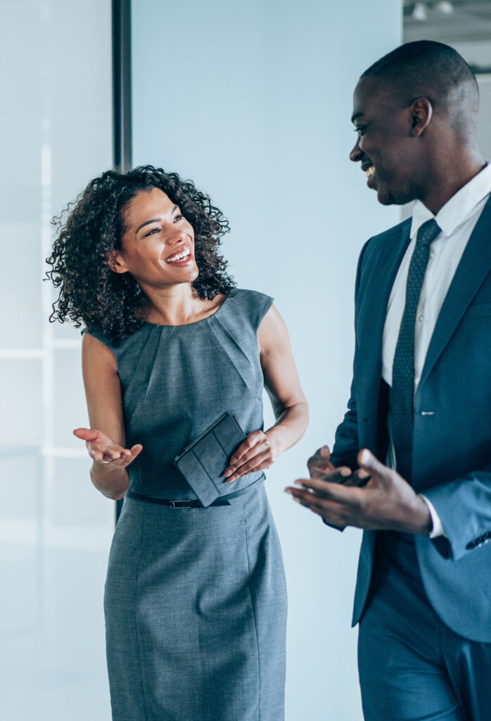 Woman and man in business formal clothes walking together and discussing