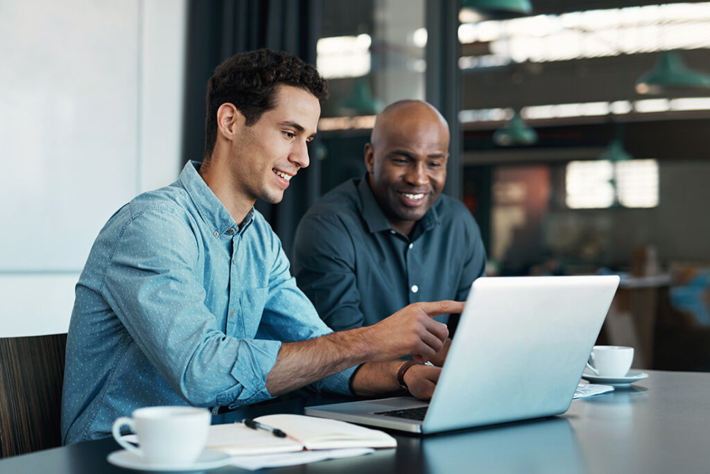 Two men in front of a laptop