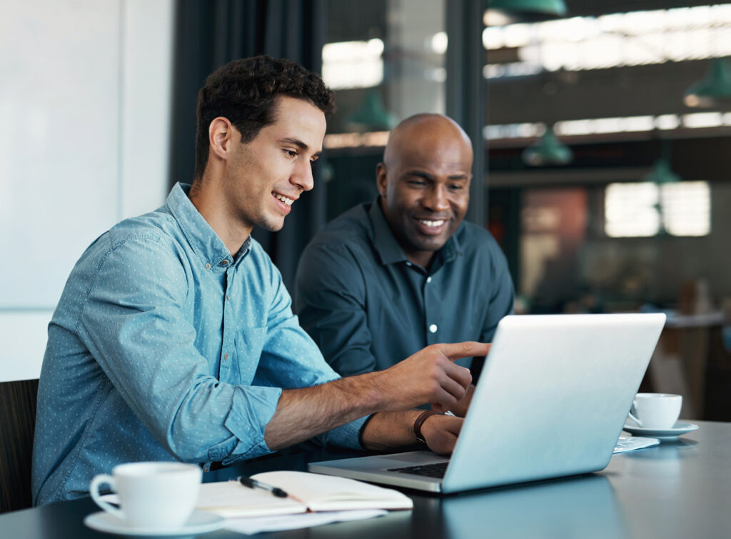 Two men in front of a laptop